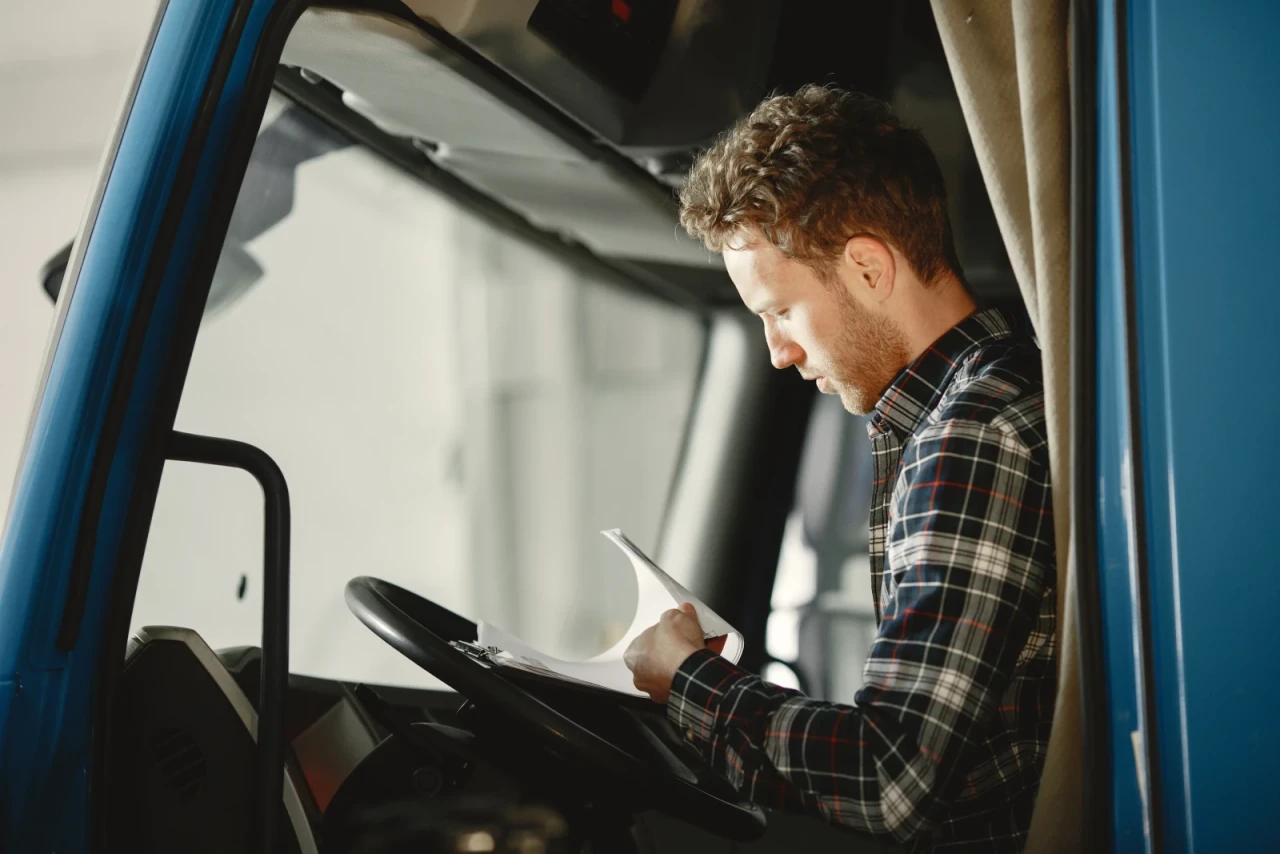 Driver in a blue shirt with a phone after delivering goods
